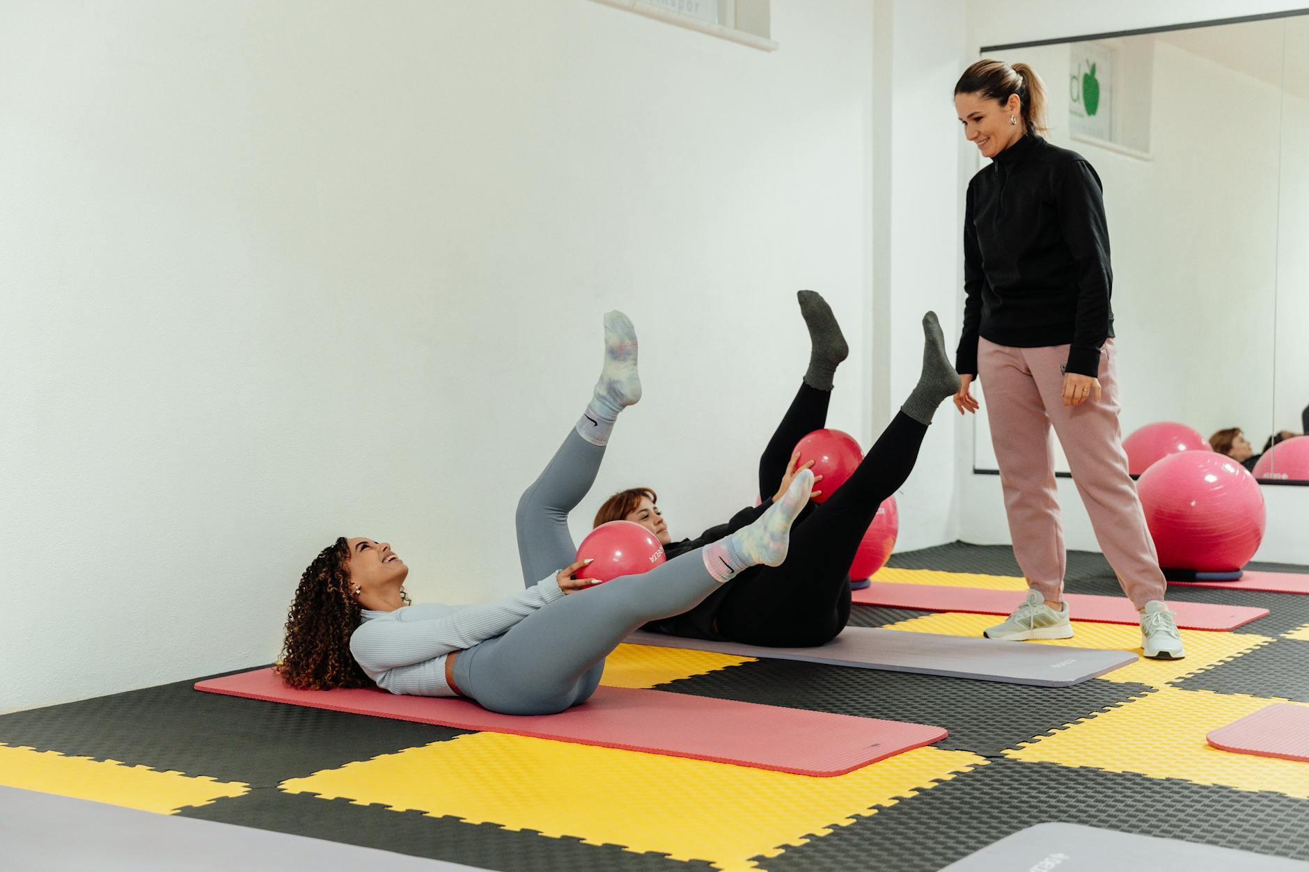 Duas mulheres se exercitando com bolas de pilates