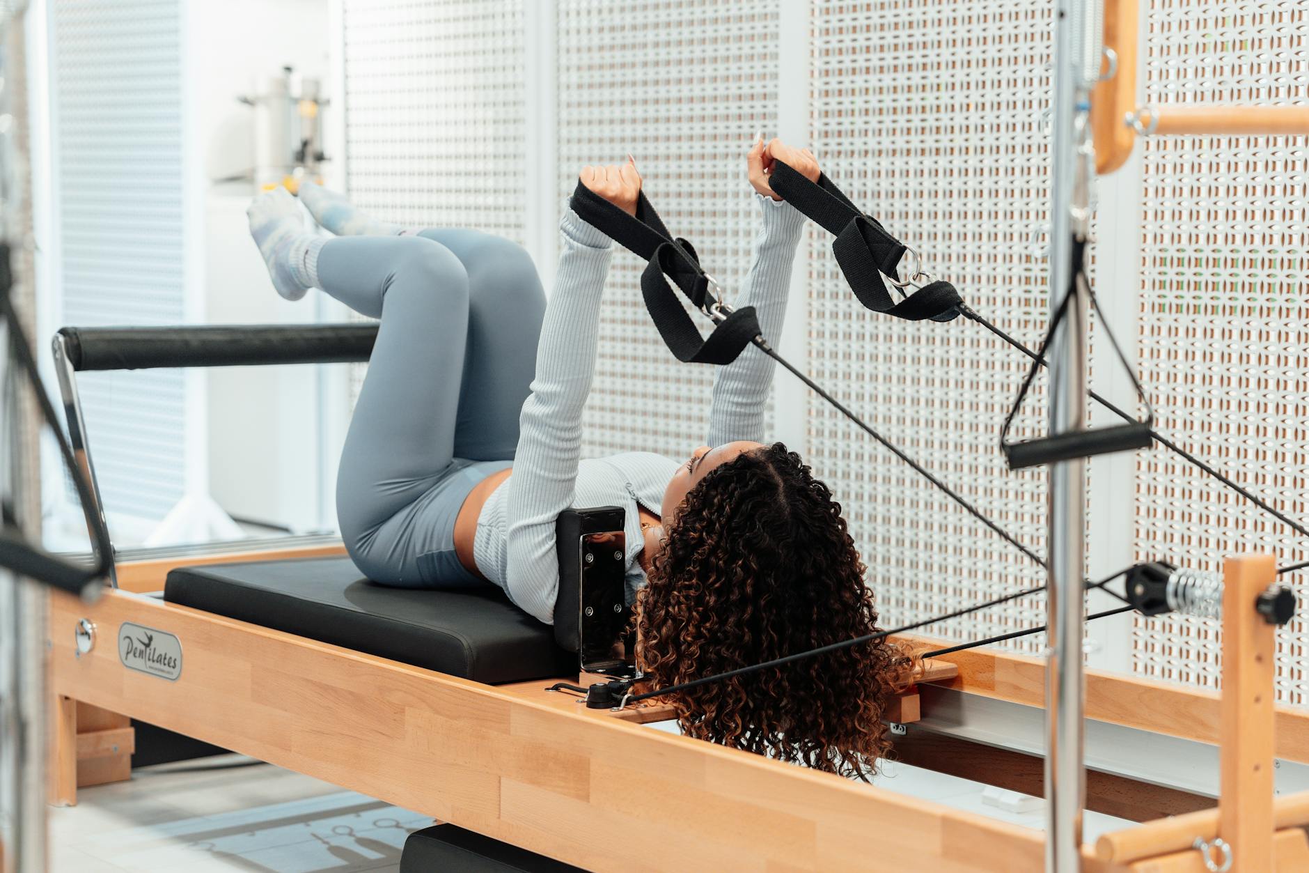 Mulher praticando pilates em reformer